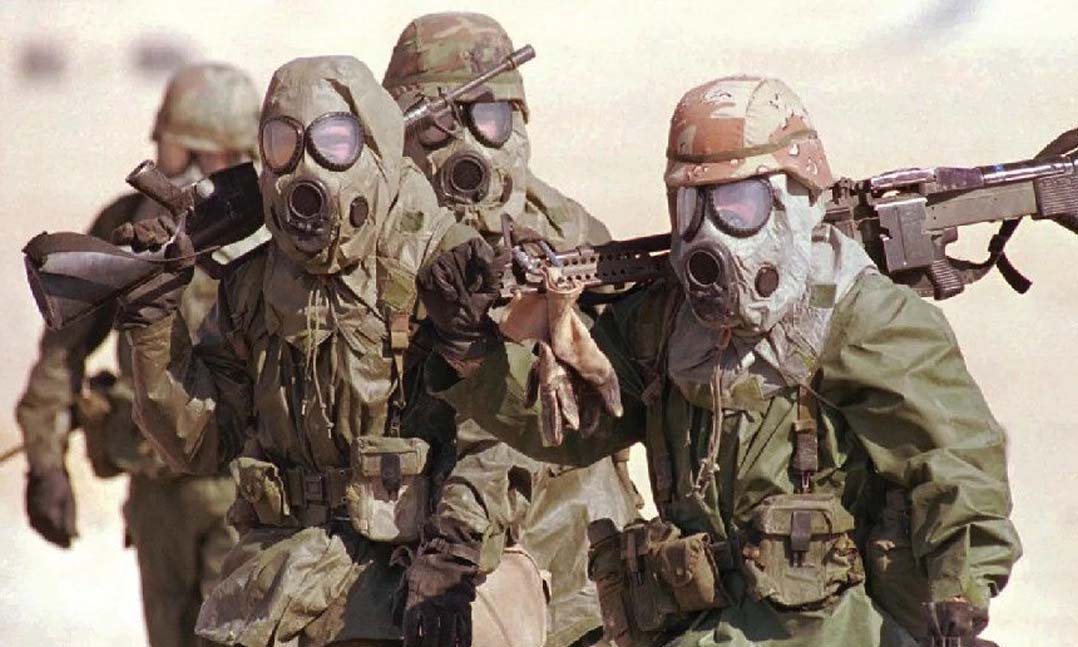 Soldiers from the 24th Mechanized Infantry Brigade from Fort Stewart, Ga., carry their weapons as they undergo chemical training in eastern Saudi Arabia during Operation Desert Shield in November 1990.