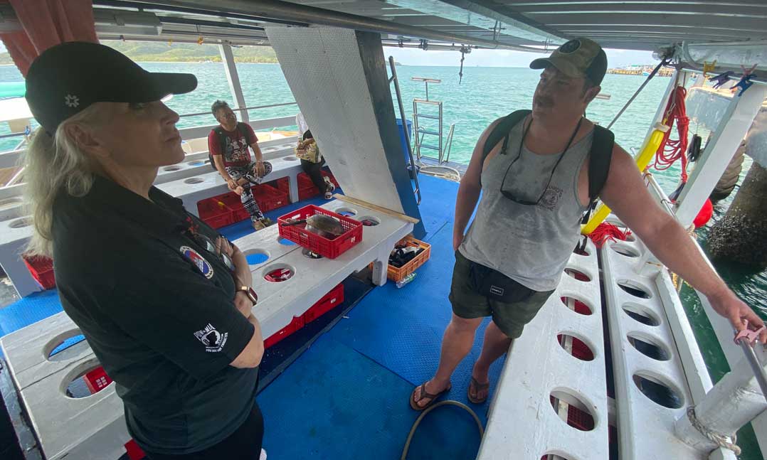 Then-VFWJunior Vice Commander-in-Chief Carol Whitmore listens to a dive supervisor while on a trip to a crash site in the Gulf of Thailand