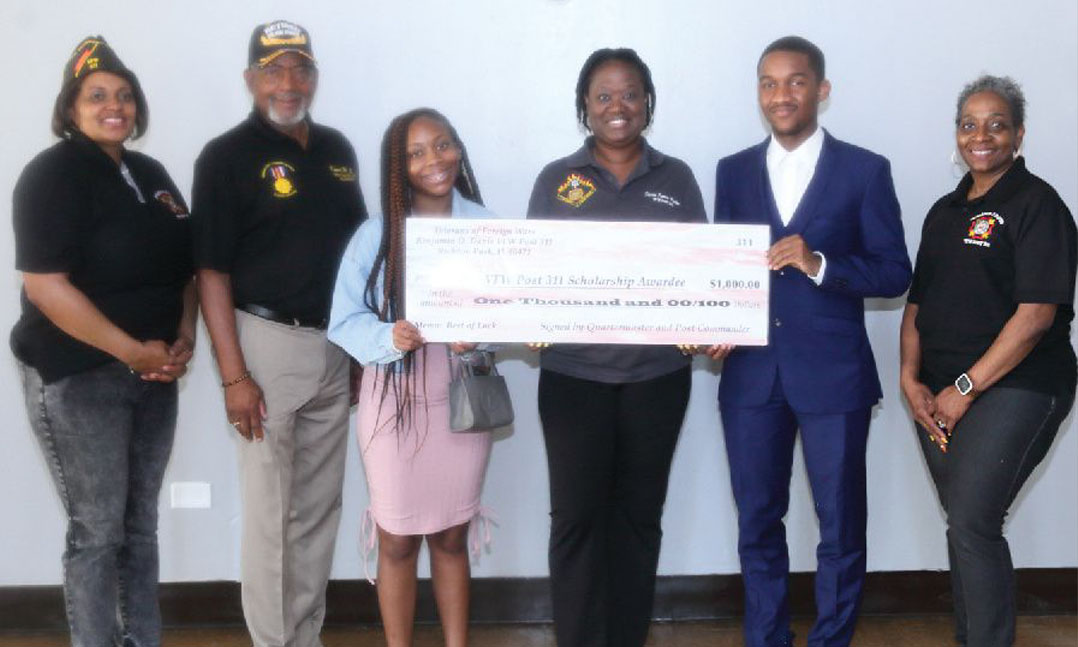 Members of VFW Post 311 present students with a scholarship