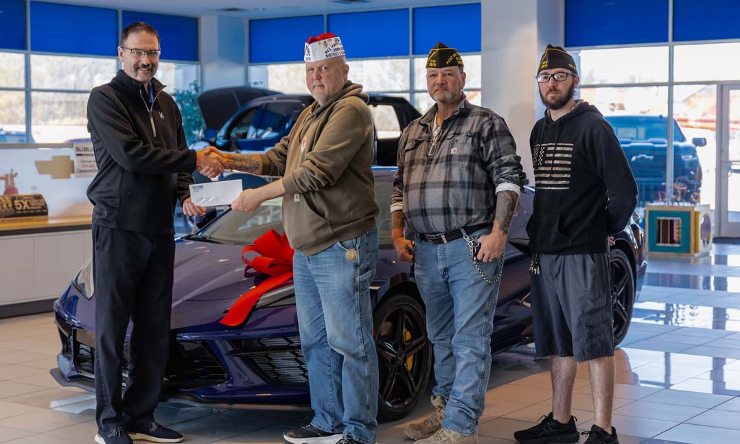 Suburban Chevrolet Community Outreach Liaison Preston Gooding, left, presents a charitable donation to members of VFW Post 2976
