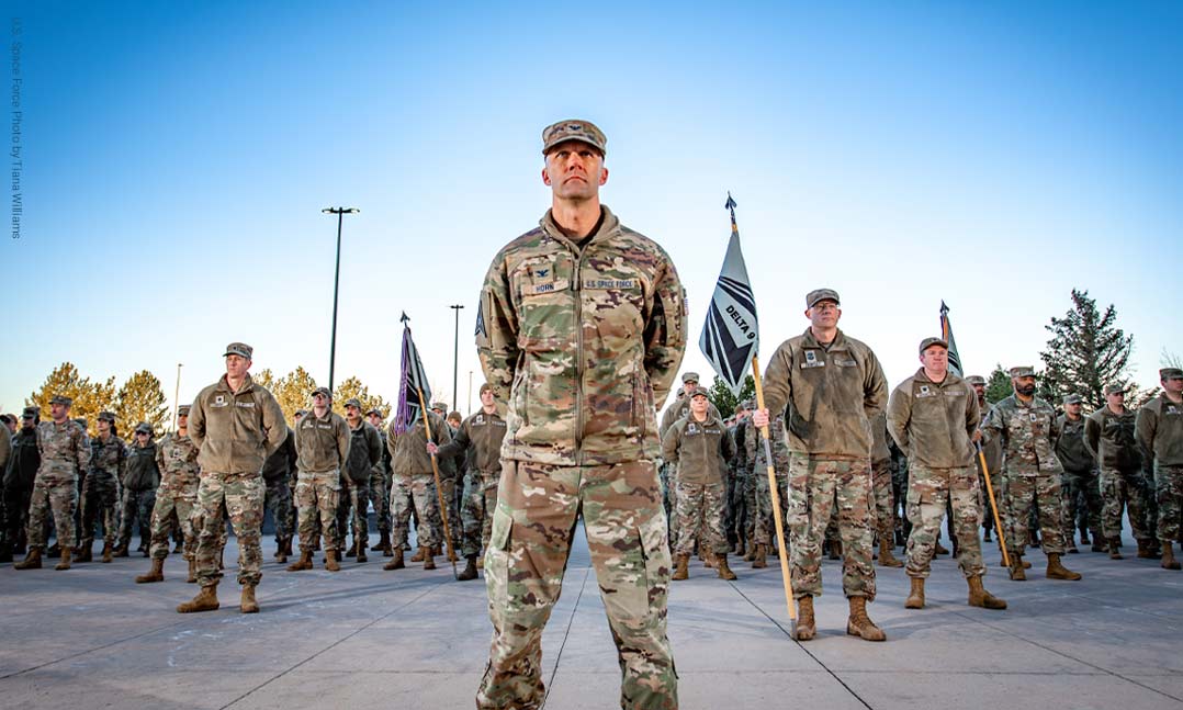 United States Space Force Colonel Ramsey Horn, Commander Space Delta 9, stands at parade rest before the playing of reveille