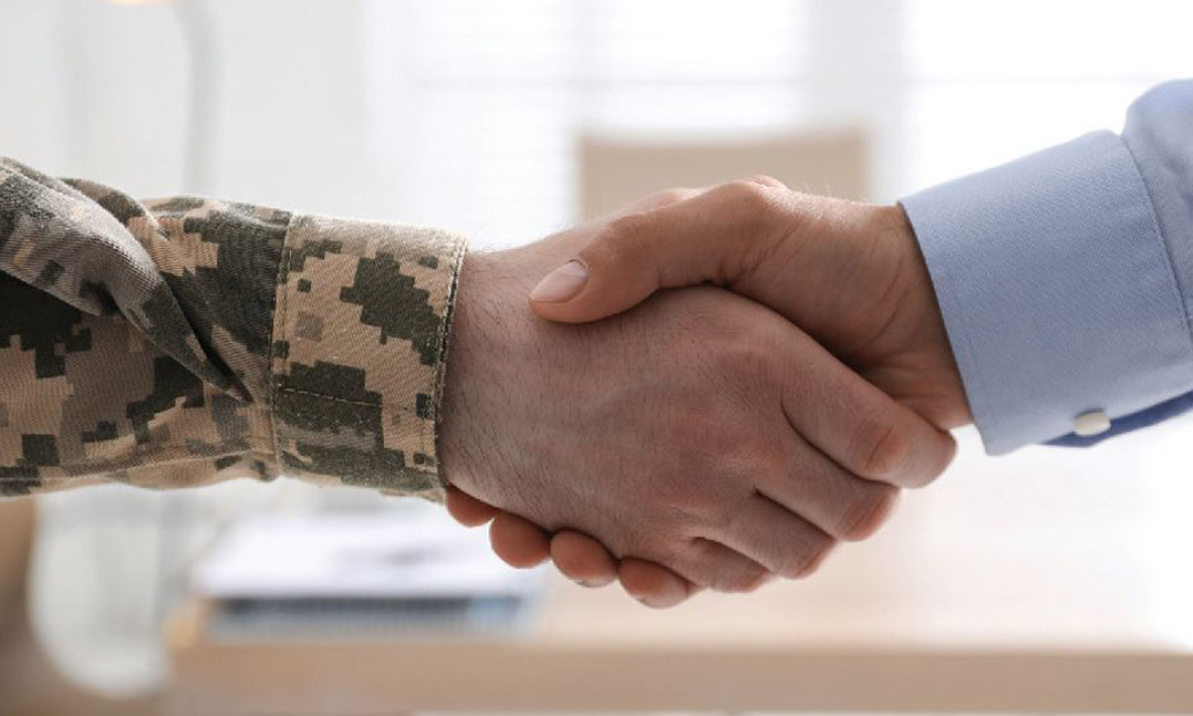 Military hand shaking business hand