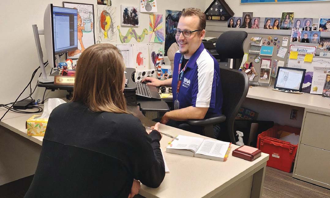 VFW Veterans Service Officer Jeffrey Cowell helps a fellow veteran with her VA claim at Fort Snelling, Minn., in October 2024.